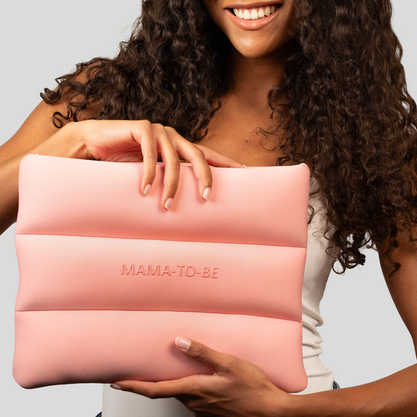 Woman holding the Skin Load Mama-To-Be Bag in blush pink padded neoprene