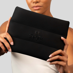 Model holding the Skin Load black padded Makeup Pouch in both hands
